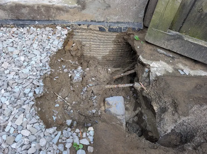 Foundation wall and exposed footing during basement crack repair work