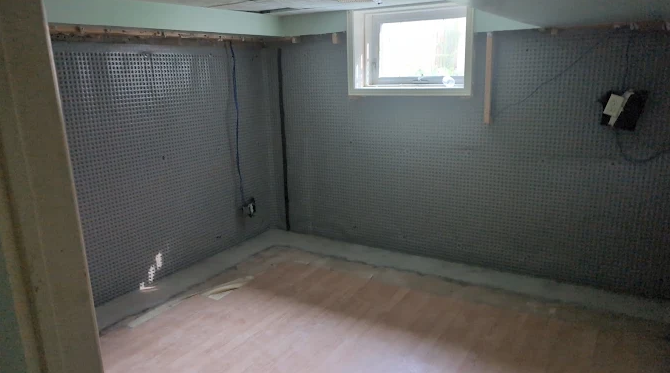 Interior basement wall protected with dimple waterproofing membrane