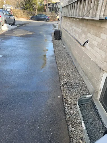 Waterproofing workers excavating beside a brick foundation wall in Toronto