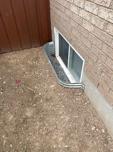 Exterior foundation wall with waterproofing membrane applied beside an excavated trench